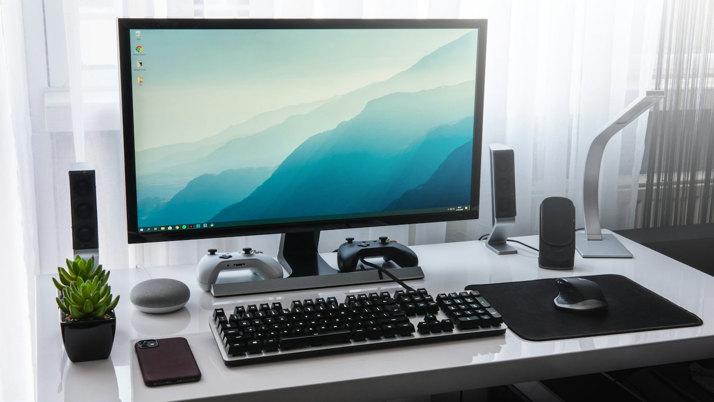Poste de travail avec écran, clavier et souris sur un bureau blanc